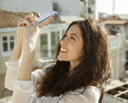 Image of a woman taking a video with a smartphone